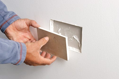 Så reparerar du hål i vägg med två lager gips (stora hål): Applicera ett tunt lager gipsskivelim runt hålets kanter, och på ett par punkter mitt på den inre skivan. Så reparerar du hål i vägg med två lager gips (stora hål): Applicera ett tunt lager gipsskivelim runt hålets kanter, och på ett par punkter mitt på den inre skivan.